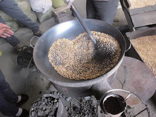 熱した砂を入れた鍋で大麦を煎っているところ